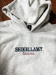 Gray hoodie with 'SHIKELLAMY braves' text on a wooden surface